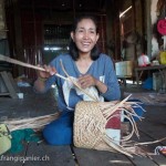 Artisanat équitable et authentique en jacinthe d'eau du Cambodge, une artisane confectionne un panier dans sa maison flottante sur le bord du Lac Tonle Sap.